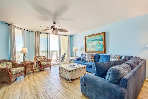 een woonkamer met een blauwe bank en stoelen bij Charleston Oceanfront Villas 112 in Folly Beach