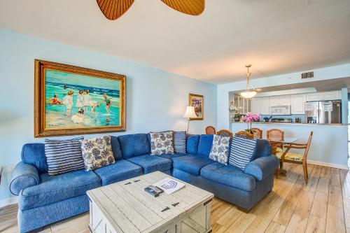 een woonkamer met een blauwe bank en een tafel bij Charleston Oceanfront Villas 112 in Folly Beach