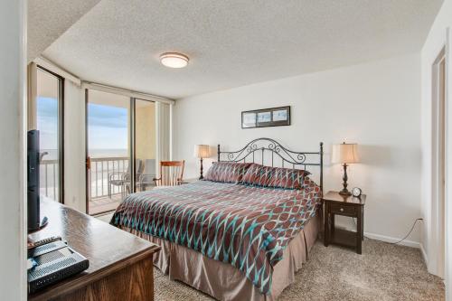 a bedroom with a bed and a balcony at Charleston Oceanfront Villas 311 in Folly Beach