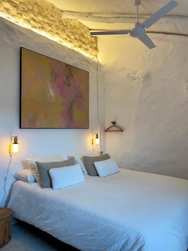 a bedroom with a white bed with two white pillows at Casa Tohca Setenil in Setenil