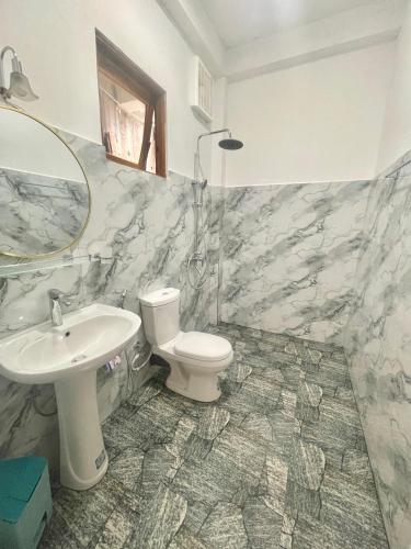 a bathroom with a toilet and a sink at Snuggle Cottage in Ella