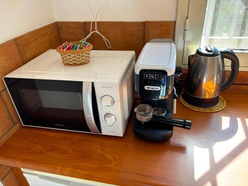 a microwave sitting on a counter next to a coffee maker at Makara Case Vacanza in Eraclea Minoa