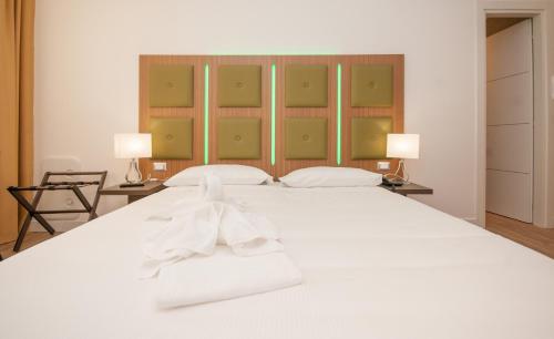 a bedroom with a large white bed with two lamps at Vatican Relais Rome in Rome