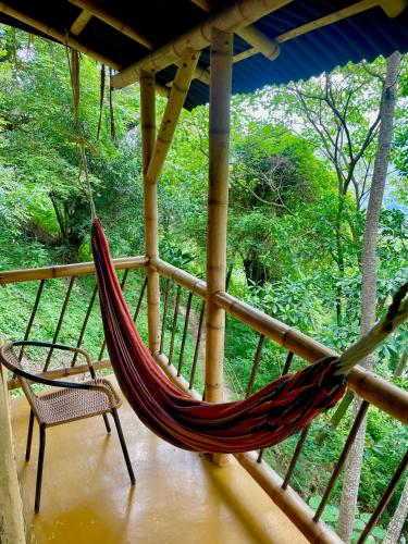 a hammock on a porch of a house at Minca Ecohabs Hotel in Minca