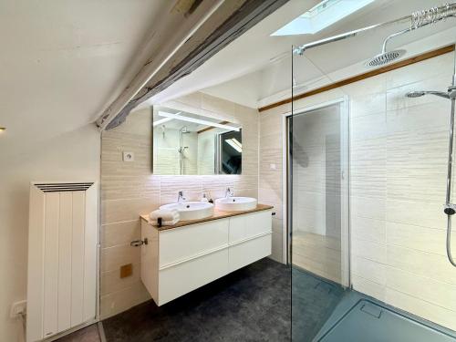 a bathroom with two sinks and a glass shower at 9 couchages - Proche Disneyland Paris in Ferrières-en-Brie