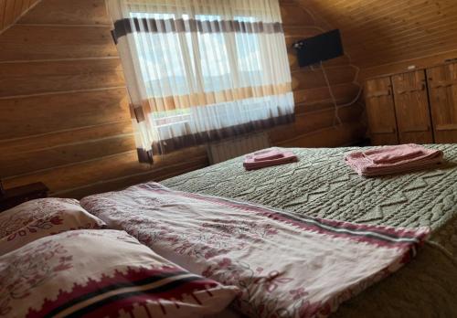 a bedroom with a bed with two towels on it at У Ґазди in Synevyrsʼka Polyana