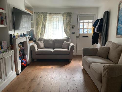 una sala de estar con un sofá y una silla en Victorian House in the heart of Richmond, en Richmond upon Thames