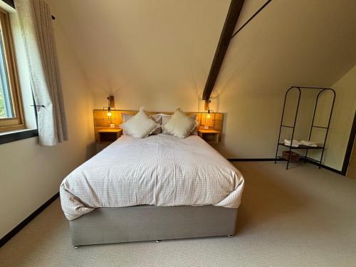 a bedroom with a bed with two lamps and a ladder at Lime Tree House - Sleeps 12 - Hot Tub in Sudbury