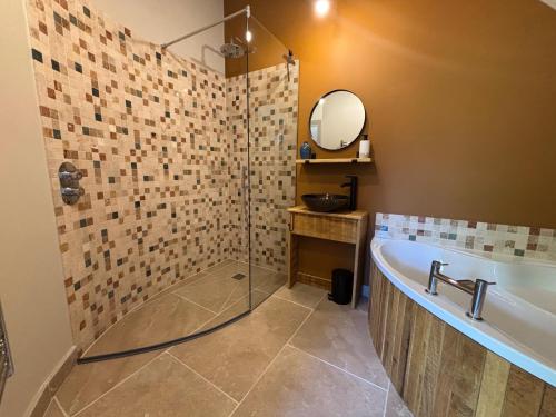 a bathroom with a bath tub and a mirror at Lime Tree House - Sleeps 12 - Hot Tub in Sudbury