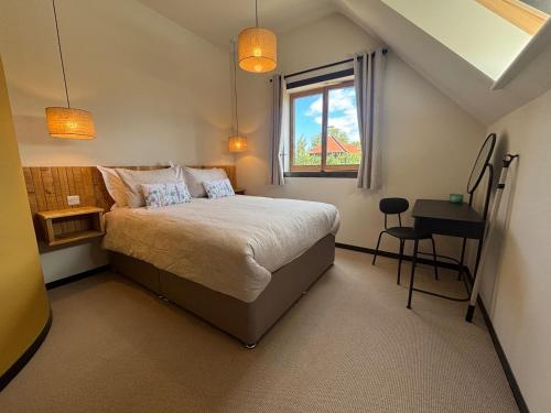 a bedroom with a bed and a window and a desk at Lime Tree House - Sleeps 12 - Hot Tub in Sudbury