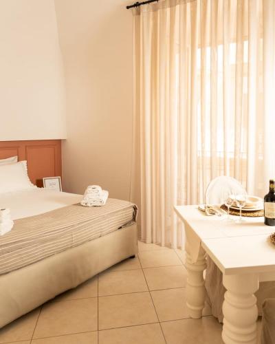 a bedroom with a bed and a table and a window at La Casetta di Giadapia - Apulia Houses & Flats in Ruvo di Puglia