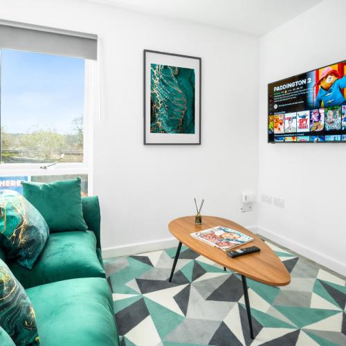 a living room with a green couch and a table at Stylish 2 Bed Apartment - Off-Street Parking - High Speed Wifi - Netflix 56C in Sleightholme