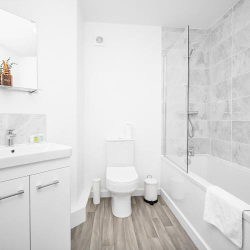 a white bathroom with a toilet and a shower at Stylish 2 Bed Apartment - Off-Street Parking - High Speed Wifi - Netflix 56C in Sleightholme