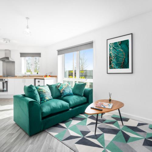 a living room with a green couch and a table at Stylish 2 Bed Apartment - Off-Street Parking - High Speed Wifi - Netflix 56C in Sleightholme