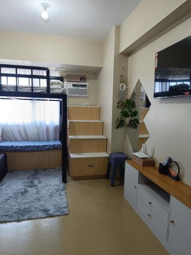 a dorm room with a bunk bed and a tv at AVIDA Aspiras Tower 2 in Cagayan de Oro