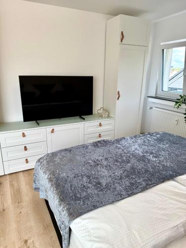 a bedroom with a flat screen tv and a bed at Modern und flexibel wohnen zwischen Köln und Düsseldorf in Langenfeld