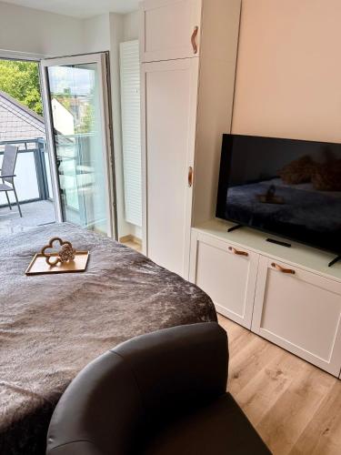 a bedroom with a bed and a flat screen tv at Modern und flexibel wohnen zwischen Köln und Düsseldorf in Langenfeld