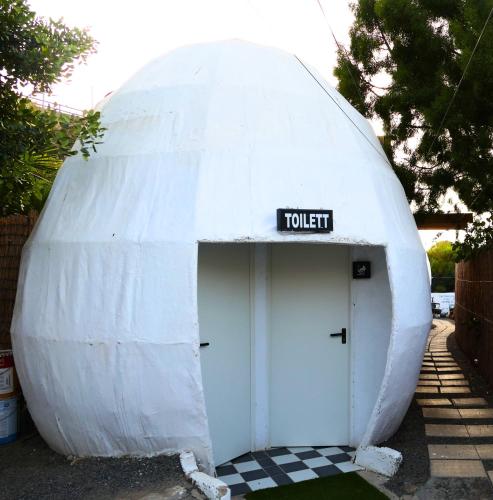 a white dome shaped building with a toilet sign on it at Casa Quetzal - Finca Oaxaca in Agaete