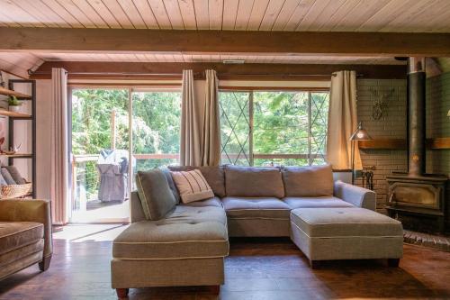 a living room with a couch and a large window at Fog & Fern Hideaway at Mount Rainier in Ashford