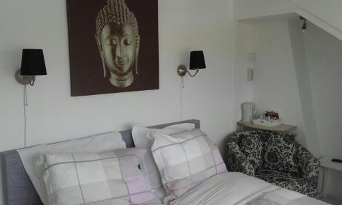 a living room with a couch and a gold mask on the wall at Pension 't hofje 350 meter van het strand in Noordwijk aan Zee