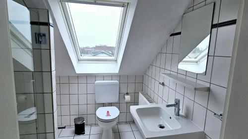 a bathroom with a toilet and a sink and a window at Büsummchen in Büsum