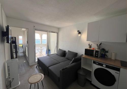 un petit salon avec un canapé et une cuisine dans l'établissement Bel appartement avec vue au Barcarès, au Barcarès