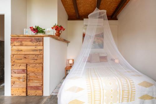 a bedroom with a bed with a mosquito net at Amrita Shala in Colares