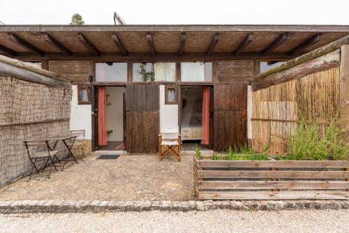 a wooden pavilion with a table and chairs on a patio at Amrita Shala in Colares