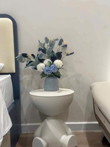 a vase of flowers on a toilet in a bathroom at Hạ Long Homestay ICON40 in Ha Long