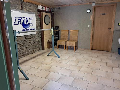 a room with two chairs and a sign on the wall at De Patuljak in Houffalize