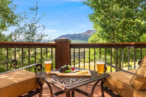 a table with two glasses of beer on a deck at Luxe Mountain Village Retreat Hot Tub with Views in Telluride