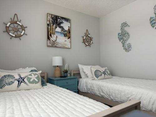 Un dormitorio con dos camas y una mesita de noche azul. en The Old City Sunshine Retreat, en St. Augustine