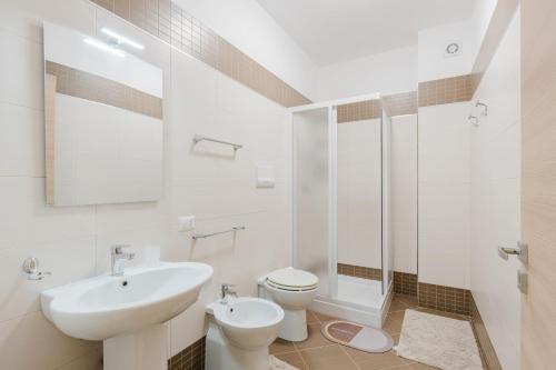 a white bathroom with a sink and a toilet at Casa Mea in Balestrate