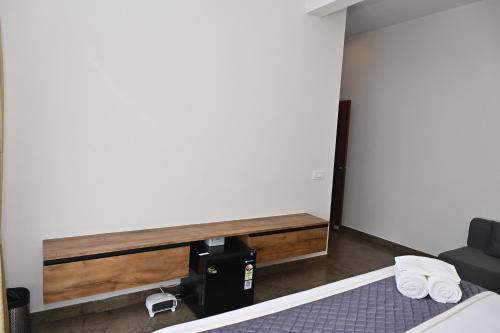 a room with a bed and a desk with towels at Tranquil Touch in Chikmagalūr