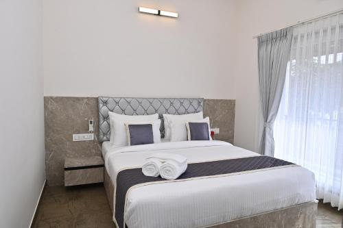 a bedroom with a large bed with two towels on it at Tranquil Touch in Chikmagalūr