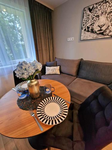 a living room with a table and a couch at Namų mūza "C" SELF CHECK IN in Plungė