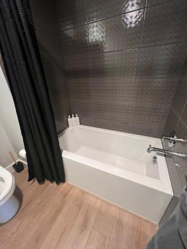 a white bath tub in a bathroom with a toilet at The Daisy Bright 2BR Stay in Downtown San Diego in San Diego
