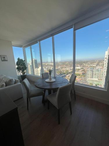 a living room with a table and chairs and large windows at The Daisy Bright 2BR Stay in Downtown San Diego in San Diego
