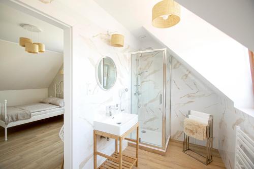 a white bathroom with a shower and a sink at Apartamenty Heweliusz House in Stegna