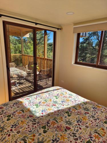 a bedroom with a bed and a view of a deck at Casa Coguil - Camino Topocalma in Los Quillayes
