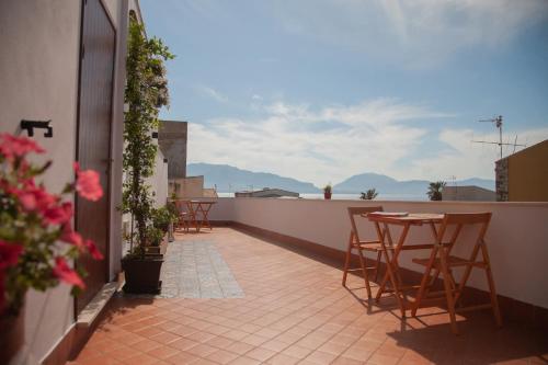 a patio with chairs and tables on a balcony at Orlando Bayview in Balestrate