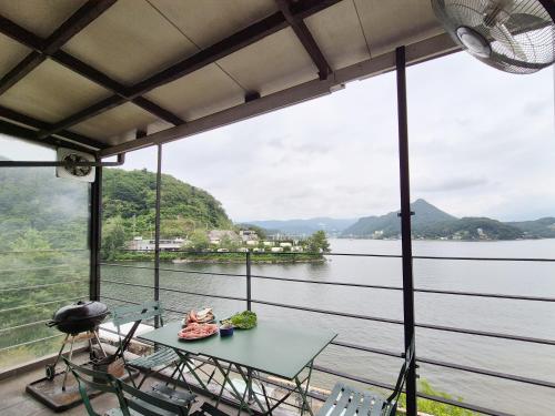 a room with a table and chairs and a view of the water at Interlaken Stay in Gapyeong