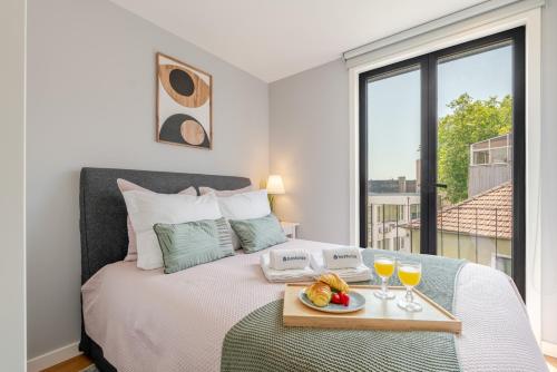 a bedroom with a bed with a tray of food on it at Stylish & Bright Apartment by HostWise in Porto