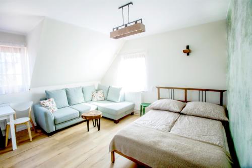 a bedroom with a bed and a couch at Apartamenty Heweliusz House in Stegna