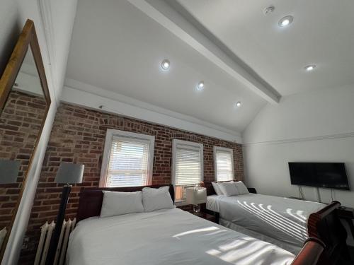 a bedroom with two beds and a brick wall at Good Night Sleep 1Bdrm 2 Queen Beds in Washington, D.C.