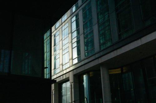 a tall building with glass windows at night at Maison Rokxy - Luxury Apartments in London