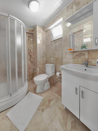 a bathroom with a toilet and a sink at Hotel Tuna in Akçay