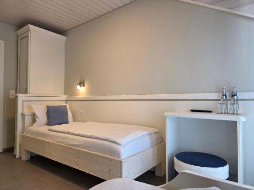a small bedroom with a bed and a desk at Hotel Salvi in Kreuzlingen