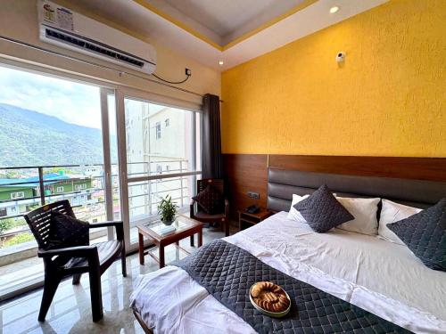 a bedroom with a bed and a large window at Hotel Uday Palace in Rishīkesh