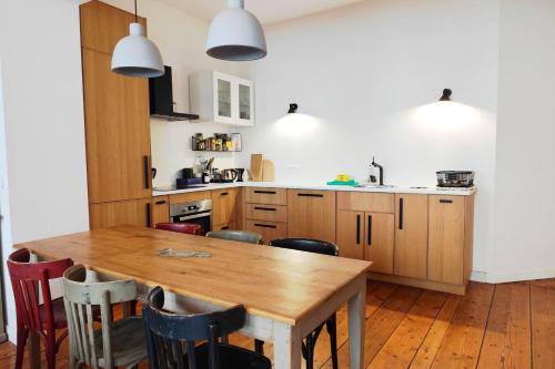 une cuisine avec une table et des chaises en bois dans l'établissement Beautiful T3 in the historic heart of Bordeaux, à Bordeaux